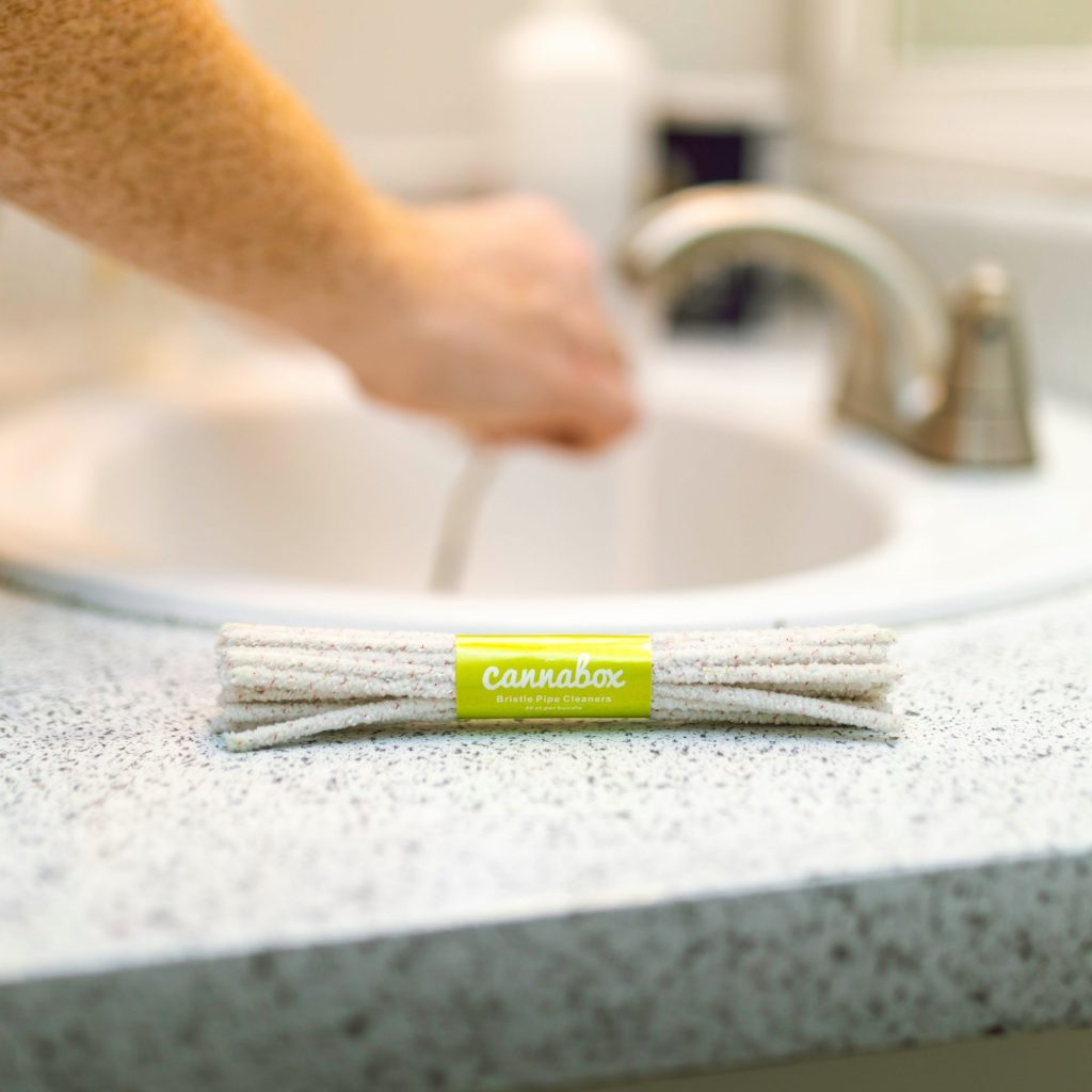 person holding white and green toothbrush