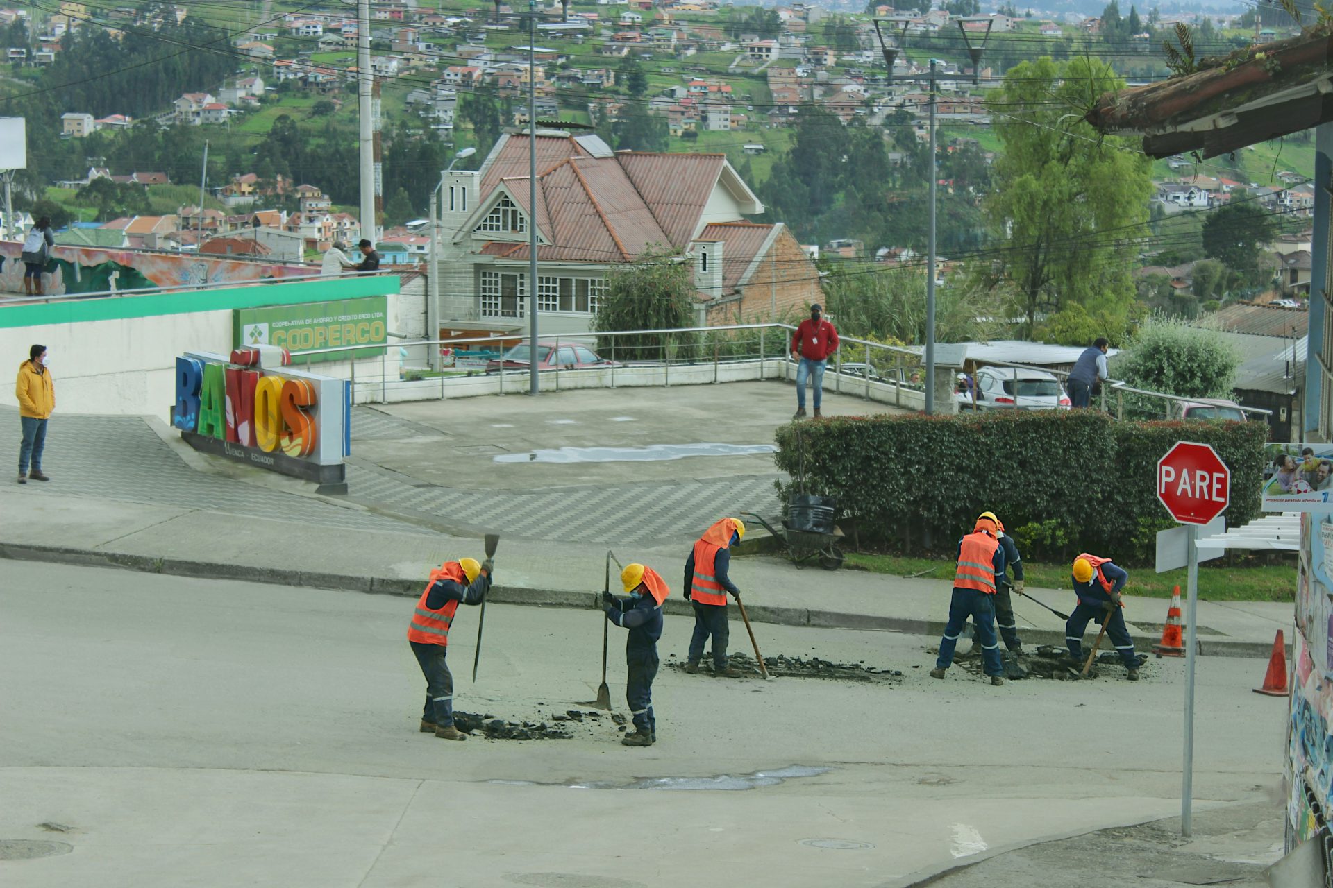 a group of people in orange vests working on a road